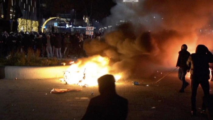 In this image taken from video, demonstrators protest against government restrictions due to the coronavirus pandemic, Friday, Nov. 19, 2021, in Rotterdam, Netherlands. Police fired warning shots, injuring an unknown number of people, as riots broke out Friday night in downtown Rotterdam at a demonstration against plans by the government to restrict access for unvaccinated people to some venues. (Media TV Rotterdam via AP)