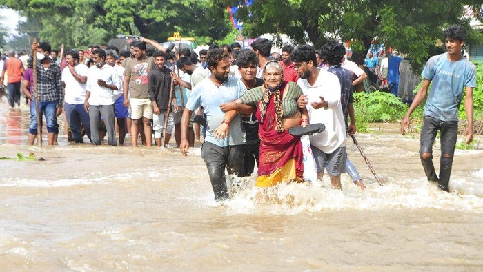 People ride a motorcycle in the rain in Hyderabad, India, Saturday, Nov. 20, 2021. More than a dozen people have died and dozens are reported missing in the southern Indian state of Andhra Pradesh after days of heavy rains, authorities said. (AP Photo/Mahesh Kumar A.)