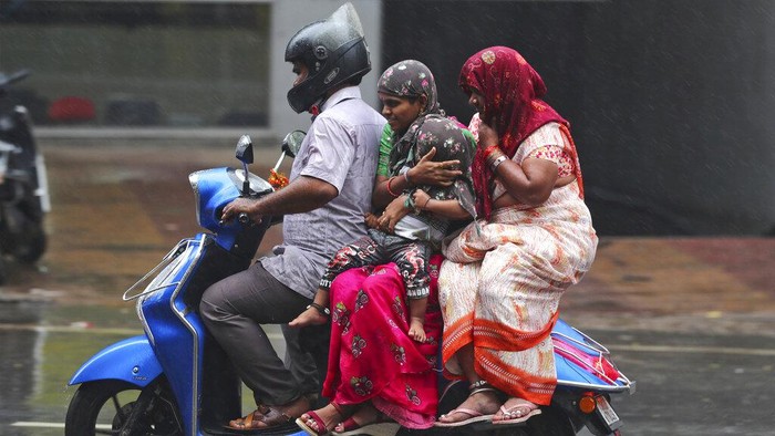 People ride a motorcycle in the rain in Hyderabad, India, Saturday, Nov. 20, 2021. More than a dozen people have died and dozens are reported missing in the southern Indian state of Andhra Pradesh after days of heavy rains, authorities said. (AP Photo/Mahesh Kumar A.)