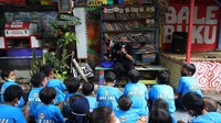 Relawan Adi Pamungkas mengajarkan mendongeng dan mengajarkan membaca buku di Bale Buku, Cakung, Jakarta, Sabtu (20/11/2021).