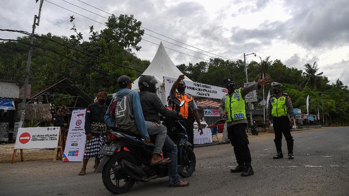 Anggota Polisi mengarahkan pengendara motor untuk mencari jalan lain di pos penyekatan kendaraan, Kuta Mandalika, Lombok Tengah, Nusa Tenggara Barat, Sabtu (20/11/2021). Polda Nusa Tenggara Barat memberlakukan pembatasan kendaraan di kawasan Mandalika saat berlangsungnya WoldSBK. ANTARA FOTO/Sigid Kurniawan/wsj.