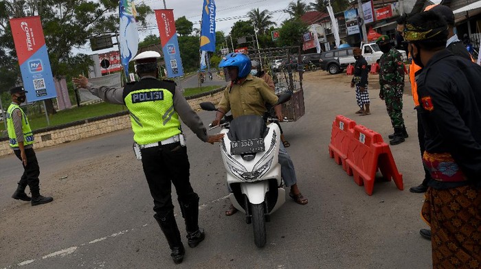 Anggota Polisi mengarahkan pengendara motor untuk mencari jalan lain di pos penyekatan kendaraan, Kuta Mandalika, Lombok Tengah, Nusa Tenggara Barat, Sabtu (20/11/2021). Polda Nusa Tenggara Barat memberlakukan pembatasan kendaraan di kawasan Mandalika saat berlangsungnya WoldSBK. ANTARA FOTO/Sigid Kurniawan/wsj.