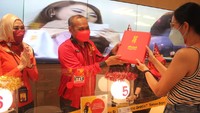 Head of Jabotabek Regional Technology Indosat Ooredoo Doly Simbar memberikan bingkisan kepada pelanggan.