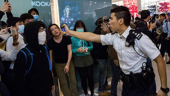 Penampakan seorang polisi menyemprotkan semprotan lada kepada seorang demonstran di kawasan Hong Kong pada 2015 silam. Diketahui, smprotan lada diciptakan oleh Kamran Loghman pada tahun 1980-an. Photo by Lam Yik Fei/Getty Images.