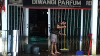 Banjir yang merendam Jalan Lintas Melawi, Sintang, Kalbar, pun terpantau mulai surut pada Jumat (19/11/2021) lalu. Tak sedikit warga yang kembali ke rumah untuk membersihkan sisa-sisa genangan air. ANTARA FOTO/Jessica Helena Wuysang. 