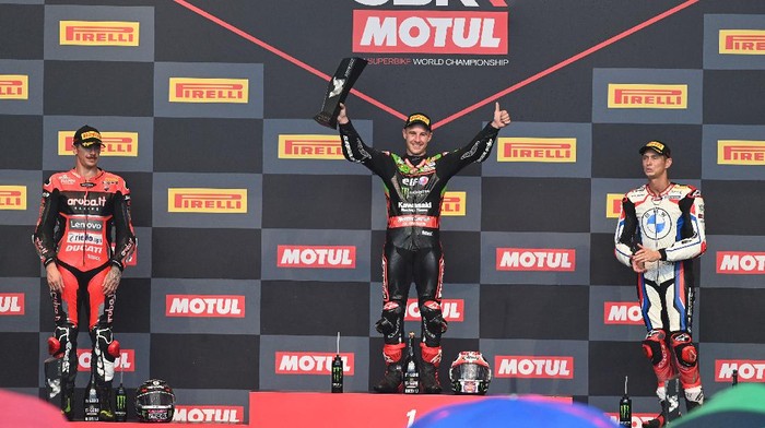 Momen Jonathan Rea Naik Podium Usai Juara Race 2 WSBK Mandalika Pebalap Jonathan Rea berhasil finis di urutan pertama dalam Race 2 WSBK Mandalika 2021. Bersama Scott Redding dan Michael van Der Mark, Jonathan Rea naik podium