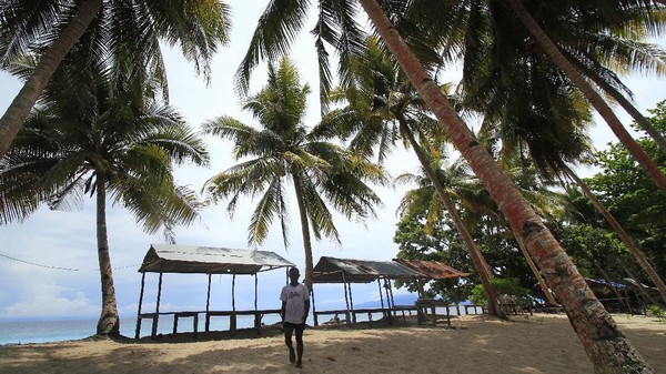 Seorang warga menikmati pemandangan di Pantai Base G, Papua, Minggu (21/11/2021).