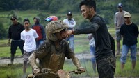 Seorang penonton memberikan minuman kepada peserta lomba.