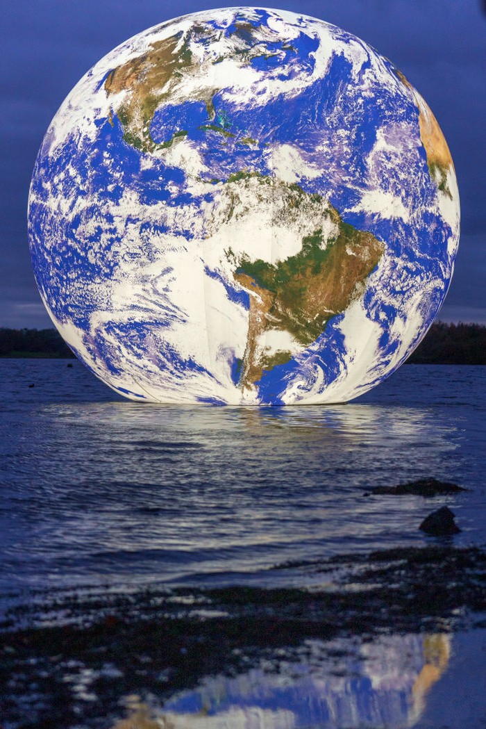 Bola Dunia Terapung di Danau, Tertarik Lihat? WIGAN, ENGLAND - NOVEMBER 18: People view artist Luke Jerram's new 'Floating Earth' Debuts In Wigan on November 18, 2021 in Wigan, England. The floating Earth will hover over Pennington Flash for 10 days from November 19, as part of a celebration of Wigan and Leigh's watercourses. It is the first time one of Jerram's globes has been floated on an open expanse of water.
(Photo by Christopher Furlong/Getty Images)