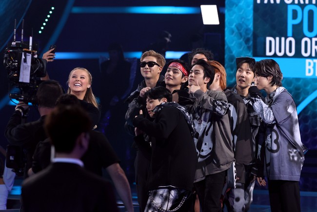 BTS pun berfoto bersama JoJo Siwa yang membacakan nominasi tersebut di atas panggung. Salah seorang penggemar bahkan menangkap momen V BTS merekam dirinya sebelum BTS diumumkan sebagai pemenang penghargaan ‘Favorite Pop Duo or Group’. Foto: Getty Images for MRC/Kevin Winter