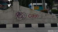 Terlihat coretan cat semprot bertuliskan CAHYO berada di dinding separator jalan. Dinding tersebut berada di bawah ornamen gambyong yang menjadi ciri khas Flyover Purwosari.