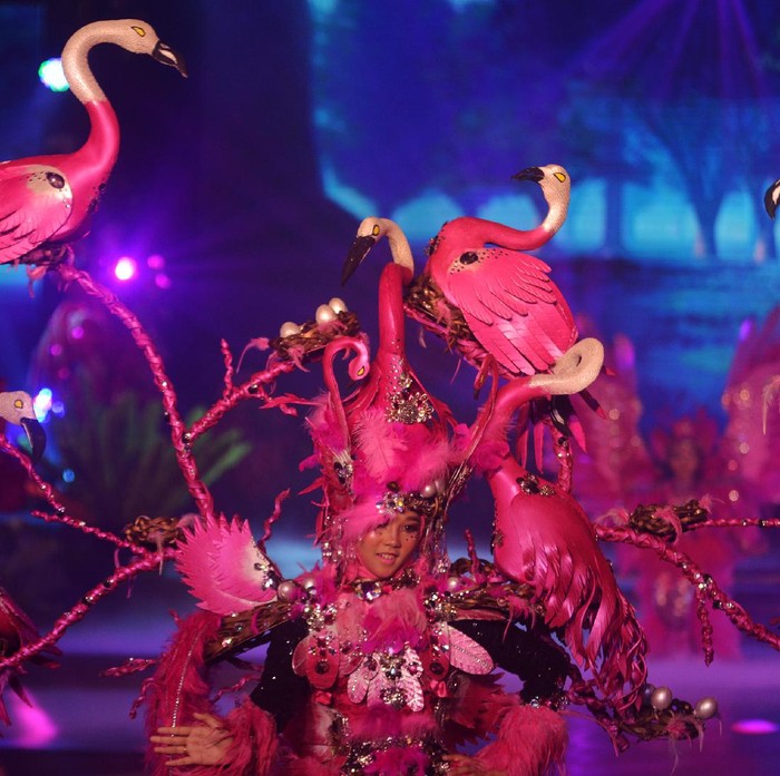Peserta defile Flamingo berjalan di atas panggung Jember Fashion Carnaval (JFC) di Jember, Jawa Timur, Minggu (21/11/2021). JFC 2021 mengangkat tema Virtue Fantasy, menampilkan sembilan defile, yaitu Komodo, Flamingo, Elephant, Sea Dragon, Dragonfly, Dove, Unicorn, Honey Bee dan Lion. ANTARA FOTO/Seno/rwa.