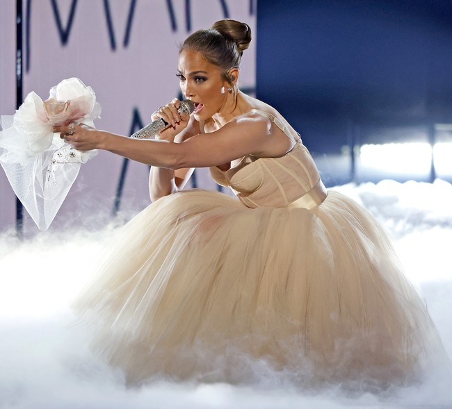 Saat tampil di American Music Awards 2021, Jennifer Lopez tampil bak karakter dalam filmnya, Marry Me, yaitu sebagai Kat Valdez. Kekasih Ben Affleck itu awalnya memakai dress hitam dan tampil di depan orkestra virtual sebelum akhirnya naik ke atas panggung dan berganti penampilan memakai busana bak pengantin. Foto: Getty Images for MRC/Frazer Harrison