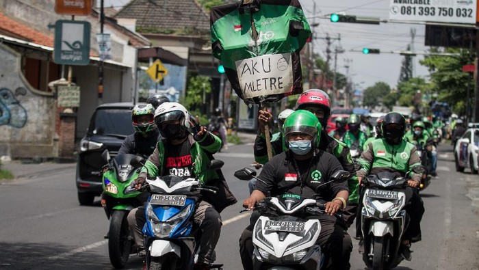 Jerit Driver Ojol di Solo Tolak Penurunan Tarif Minimum Pengemudi ojek daring berunjuk rasa menolak penyesuaian tarif dengan mendatangi kantor Gojek di Solo, Jawa Tengah, Senin (22/11/2021). Dalam aksi tersebut mereka menolak penurunan tarif minimum pesanan makanan atau layanan order GoFood dari Rp8.000 menjadi Rp6.400 karena akan mengurangi pendapatan pengemudi ojek daring. ANTARA FOTO/Mohammad Ayudha/rwa.
