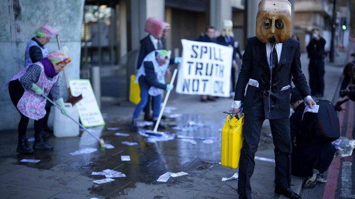 Activists from the environment group Ocean Rebellion perform a protest action outside the offices of the United Nations International Maritime Organisation (IMO) in London, Monday, Nov. 22, 2021. Ocean Rebellion were using the action on Monday to call on the IMO to agree a pathway for mandatory carbon reductions by 2030, to slash the emissions of the global shipping industry, where many large vessels run on Heavy Fuel Oil (HFO). (AP Photo/Matt Dunham)