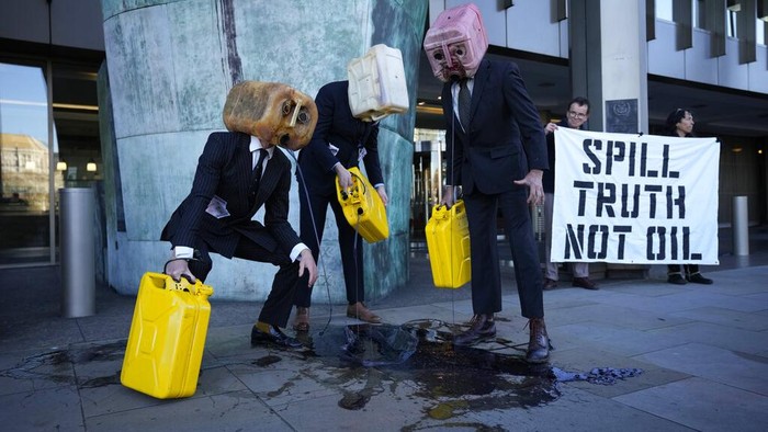 'Manusia Kepala Jeriken' Buang Limbah di Trotoar London, Ada Apa? Activists from the environment group Ocean Rebellion perform a protest action outside the offices of the United Nations International Maritime Organisation (IMO) in London, Monday, Nov. 22, 2021. Ocean Rebellion were using the action on Monday to call on the IMO to agree a pathway for mandatory carbon reductions by 2030, to slash the emissions of the global shipping industry, where many large vessels run on Heavy Fuel Oil (HFO). (AP Photo/Matt Dunham)