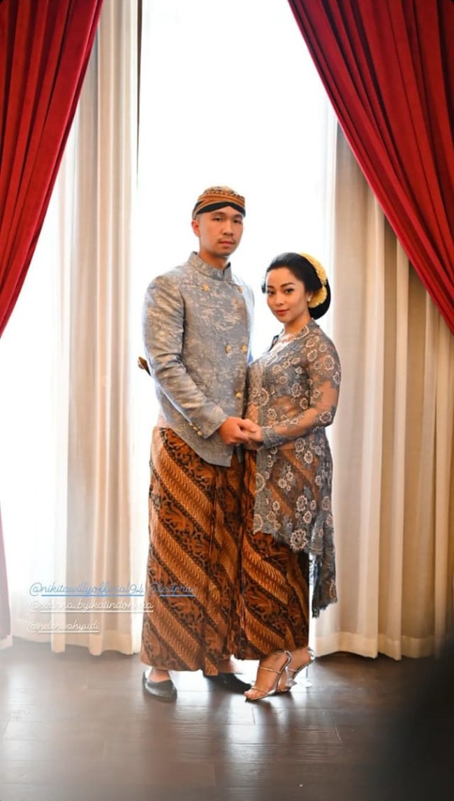 Begini foto Nikita Willy ketika berpose bersama sang suami saat menghadiri pernikahan adiknya, Winona Willy dengan Galih Baghaskara pada Minggu (21/11/21). Keduanya tampil kompak dengan busana senada. Foto: Instagram