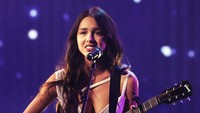 Dia membawakan lagu Traitor di atas panggung sambil memainkan gitar. (Foto: Getty Images for MRC/Kevin Winter) 