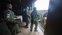 Sejumlah pasukan militer memindahkan boks ke alat berat dalam misi evakuasi puluhan ribu ayam di Abbotsford, British Columbia.