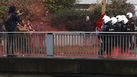 Ribuan orang memprotes aturan pembatasan COVID-19 di pusat kota Brussels pada Minggu (21/11). Mereka terutama berdemonstrasi menentang persyaratan oleh pemerintah agar masyarakat menunjukkan sertifikat vaksin di tempat umum, seperti restoran. (AP/Olivier Matthys)