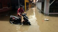 Warga menyelamatkan sepeda motornya yang terendam banjir di Kelurahan Pesurungan, Tegal, Jawa Tengah.