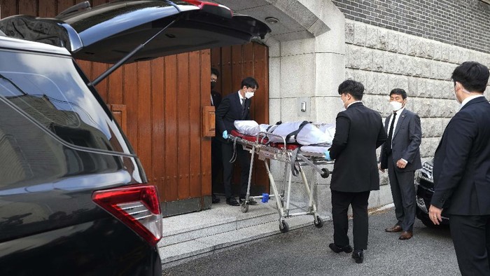 Officials bow as a funeral car carrying former South Korean President Chun Doo-hwan's body leaves his house for a funeral hall in Seoul, South Korea, Tuesday, Nov. 23, 2021. Former South Korean military strongman Chun, who crushed pro-democracy demonstrations in 1980, died on Tuesday. He was 90. (AP Photo/Ahn Young-joon)