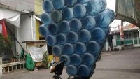 Terlalu profesional dan menjiwai, seorang pengantar air mineral galon lakukan hal yang mencengangkan. Galonnya disusun menjulang tinggi ke atas seperti menara! Foto: Istimewa