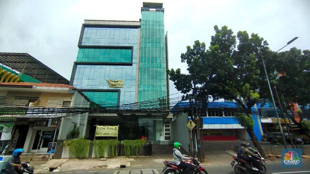 Pengendara melewati spanduk gedung yang dijual dikawasan, Jakarta, Selasa (23/11/2021). Fenomena maraknya penjualan gedung perkantoran DKI Jakarta dapat terpotret dari marketplace seperti OLX, salah satunya sebuah gedung yang berlokasi didi Mampang Prapatan, Jakarta.  (CNBC Indonesia/ Tri Susilo)