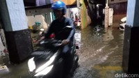 Derasnya hujan membuat air mengalir dan membanjiri gang dan masuk ke rumah-rumah warga.