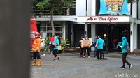 Para karyawan mengevakuasi barang-barang yang tidak terbakar.