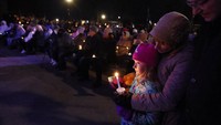 Seorang anak kecil mengambil bagian dalam nyala lilin di pusat kota Waukesha, Wisconsin, Senin, 22 November 2021 setelah sebuah SUV menabrak parade Natal hari Minggu yang menewaskan banyak orang dan melukai puluhan lainnya. (AP/Jeffrey Phelps)