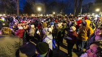 Relawan membagikan sandwich, cokelat panas, dan lilin pada acara vigil yang dihadiri oleh para pemimpin lintas agama dan pejabat terpilih.(AP/Scott Ash)