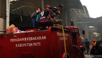 Tampak petugas pemadam kebakaran tengah bekerja memadamkan api.