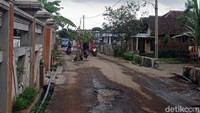Jalan tampak berlubang dan menjadi kubangan air. Kerusakan jalan yang cukup parah membuat pengendara yang melintas harus ekstra hati-hati.