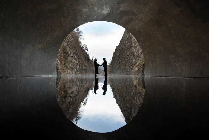 TOKAMACHI, JAPAN - NOVEMBER 21: Visitors pose for a photograph on a viewing platform with the artwork “Tunnel of Light” (Echigo-Tsumari Art Field) by Ma Yansong / MAD Architects at the Kiyotsu-kyo Gorge on November 21, 2021 in Tokamachi, Japan. (Photo by Tomohiro Ohsumi/Getty Images)