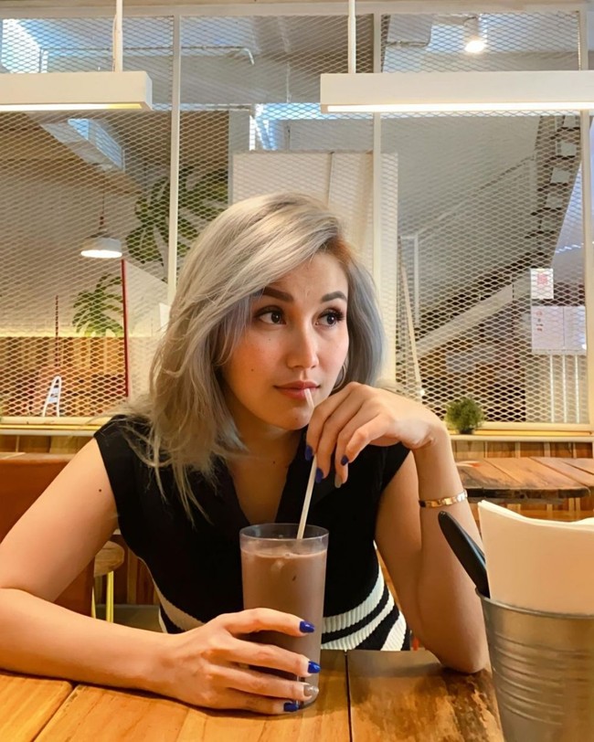 Dalam salah satu unggahannya terlihat Ayu Ting Ting yang tengah berada di sebuah restoran mengenakan baju hitam bergaris putih. Warna rambut barunya pun jadi sorotan netizen. Tak sedikit netizen yang kemudian memuji penampilan barunya itu. Foto: Instagram/@ayutingting92