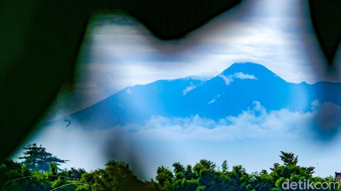 Gunung Gede-Pangrango terlihat dari Tangerang Selatan pagi ini. Gunung terlihat berawan dari kejauhan.
