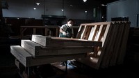 Seorang karyawan memakai masker saat merakit piano di alat musik Jinbao dari Perth Music Group. Perth Music Group memiliki delapan merek piano sendiri, termasuk Yangtze River, Wilh.Steinberg, Toyama, senberon dan Portman.