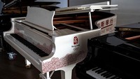 Piano yang digunakan dalam upacara pembukaan Olimpiade Beijing 2008 berada di aula pameran alat musik Jinbao dari Perth Music Group.