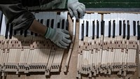 Seorang karyawan sedang membuat tuts piano. Industri Alat Musik Jinbao telah menjadi salah satu dari tiga basis produksi piano utama di dunia.