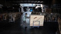 Seorang karyawan memindahkan papan prototipe untuk membuat piano. Perth Music Group memiliki delapan merek piano sendiri.