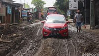 Muhadi menyampaikan, kondisi jalan yang dahulu beraspal kini berlubang dan tergenang lumpur. Bahkan, kedalaman lubang di depan rumahnya hampir 1 meter.