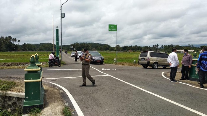 Petugas Dishub Sleman memasang lampu PJU di Kapanewon Minggir yang rawan kecelakaan.