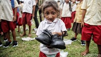 Seorang siswa menunjukkan sepatu yang diberikan oleh relawan CT Arsa Foundation di SDN Reda Meter, Desa Kadu Eta, Kecamatan Kodi Utara, Kabupaten Sumba Barat daya, Nusa Tenggara Timur (NTT).