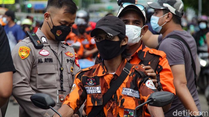 Polisi merazia massa Pemuda Pancasila (PP) usai dipukul mundur dari depan gedung DPR, Jakarta. Sejumlah senjata tajam disita.