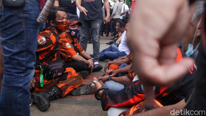 Polisi merazia massa Pemuda Pancasila (PP) usai dipukul mundur dari depan gedung DPR, Jakarta. Sejumlah senjata tajam disita.