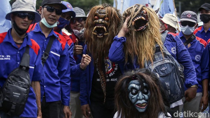 Aksi para buruh di kawasan Patung Kuda, Jakarta, diwarnai pemandangan unik. Sejumlah buruh tampak mengenakan pakaian tak biasa bak 'Genderuwo'. Ini potretnya.