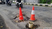 Selain berlubang, jalan yang sedikit menikung itu terdapat tebaran pasir yang bisa membuat pemotor tergelincir.