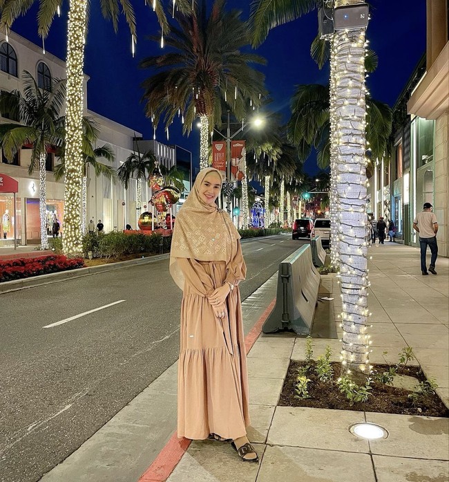 Kartika Putri membagikan foto saat berada di Rodeo Drive, Beverly Hills, California. Ia memakai dress dan hijab monogram koleksi rancangan Ivan Gunawan. Btw makasih ka @ivan_gunawan sudah bekelin @ivangunawanprive nya langsung 1 set semua jadi aku bisa tetep tampil he’eh hahahaha sayang ka Igun💐, ucap Kartika. Foto: Dok. Instagram @kartikaputriworld.