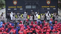 Pantauan detikcom, Kamis (25/11/2021), sekitar pukul 12.20 WIB, massa buruh mendengar putusan MK secara online. Mereka mendengarkan putusan sambil duduk.